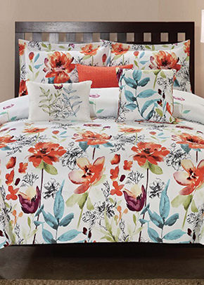 bed with white comforter and bright floral design
